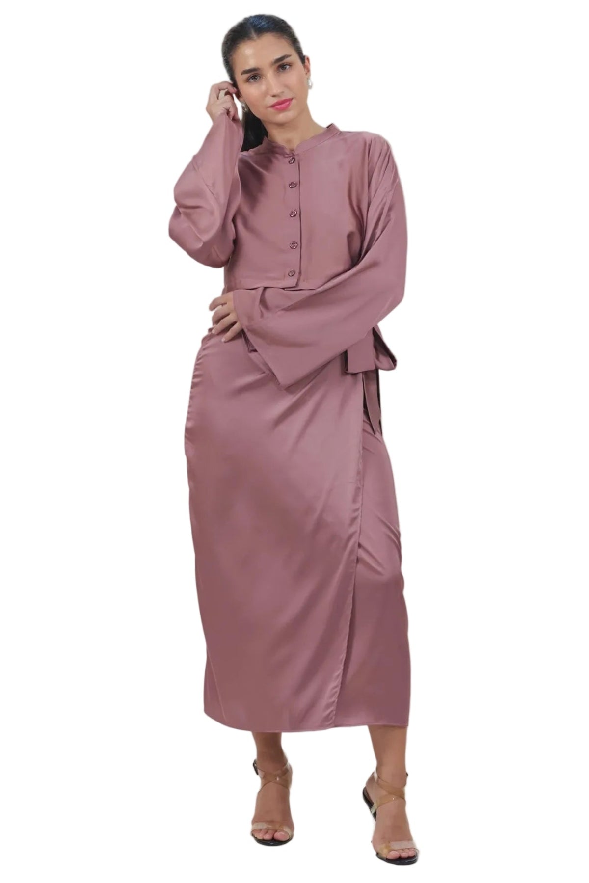 A woman modeling a dusty rose abaya dress with a high collar, buttoned front, and long sleeves, standing against a solid white background.