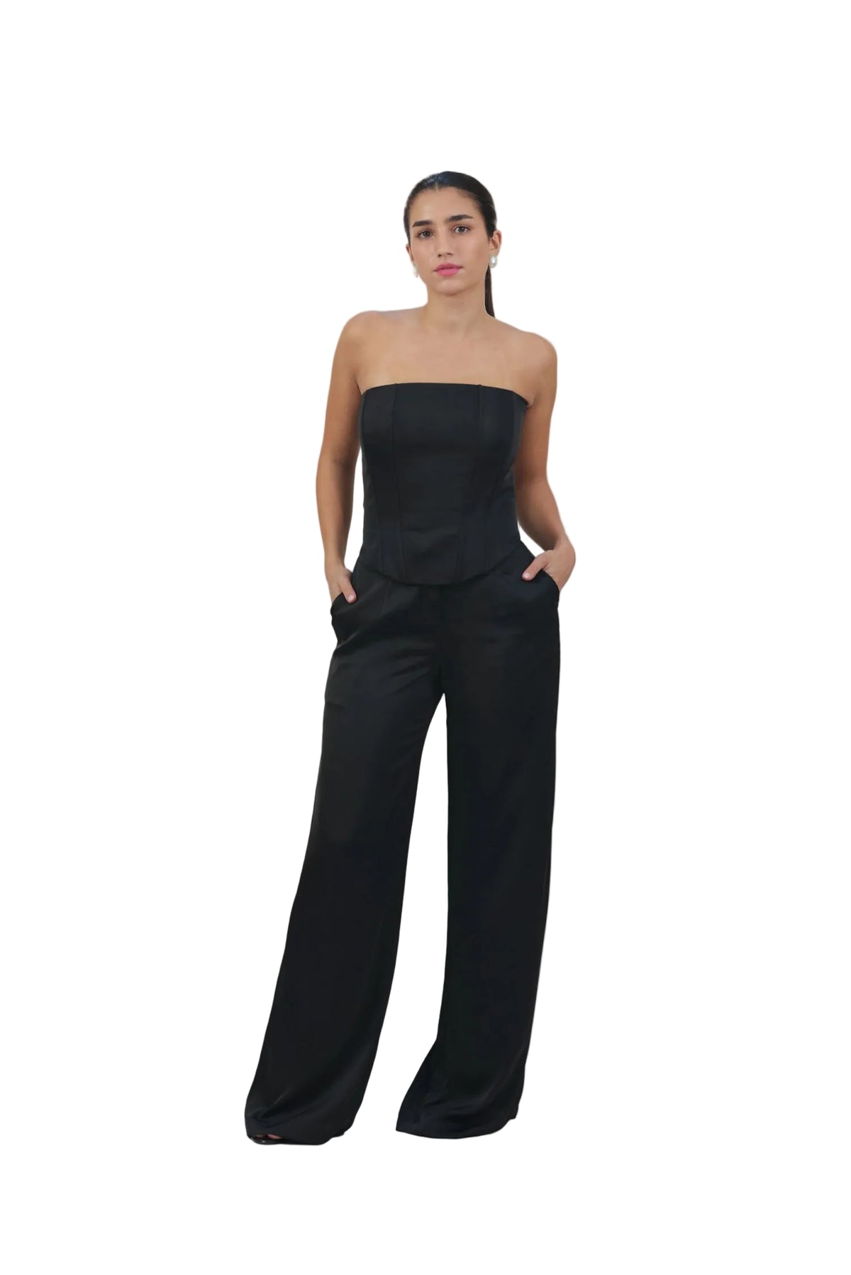 Woman wearing a black strapless jumpsuit on a beige background