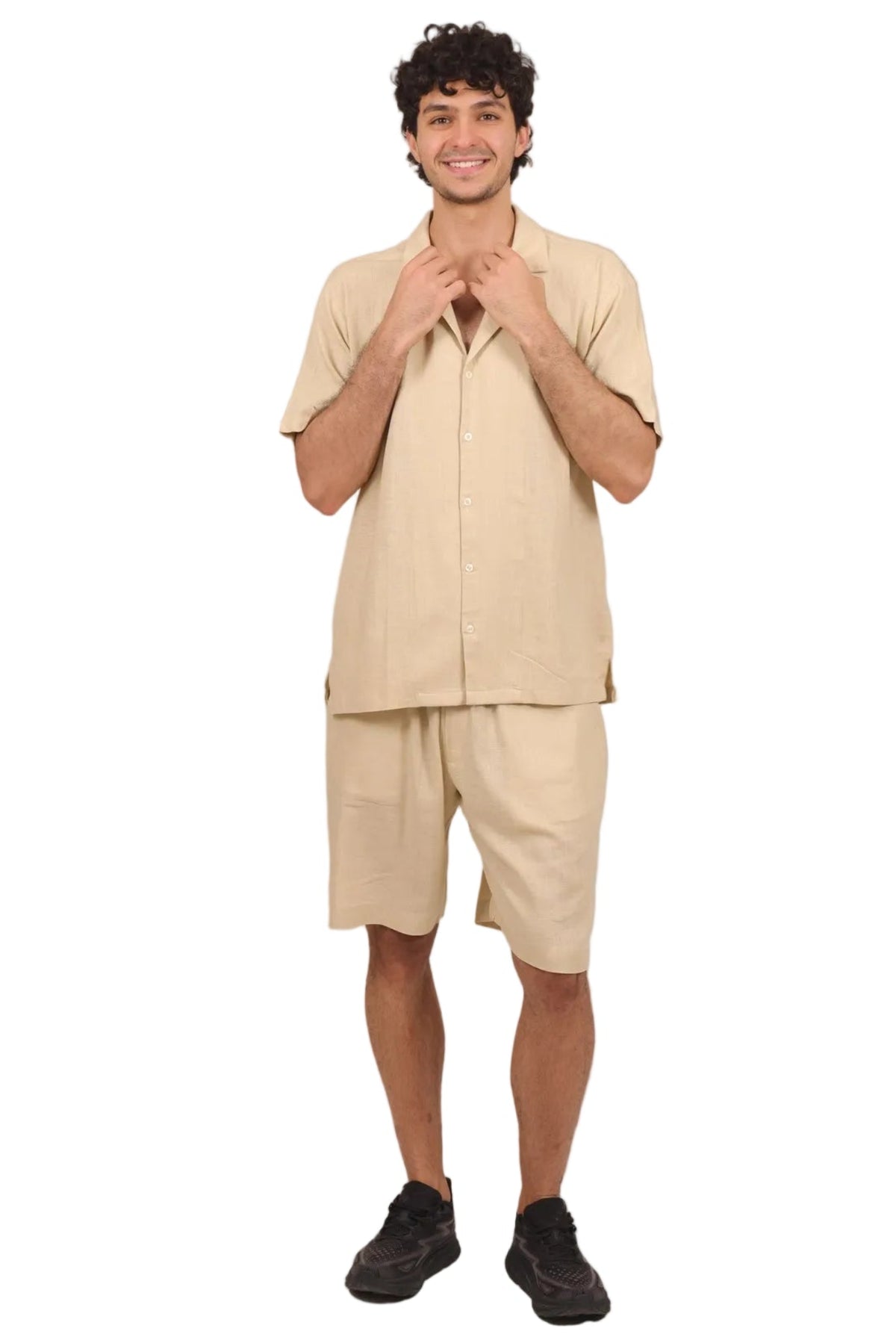 A man modeling a light beige linen short-sleeve shirt and matching linen shorts against a solid white background.