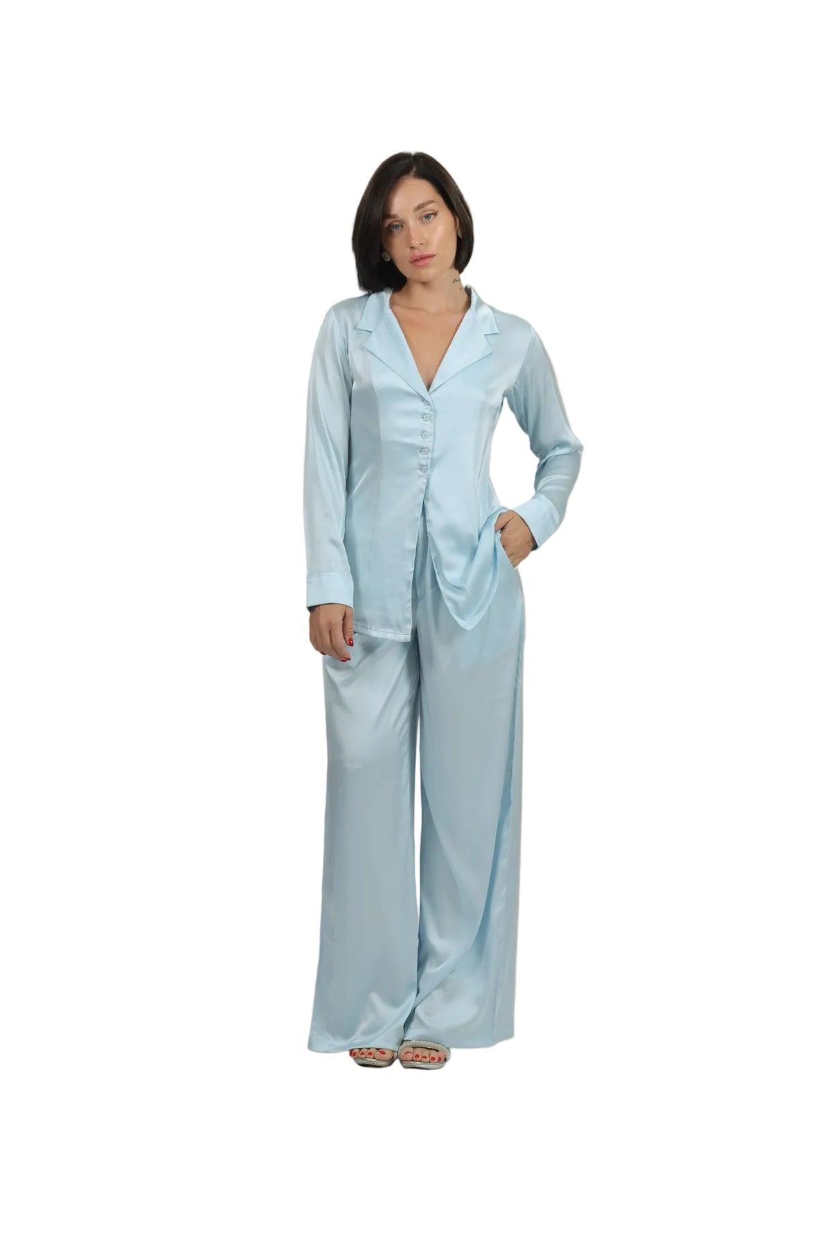 Woman wearing a light blue satin pajama set against a beige background