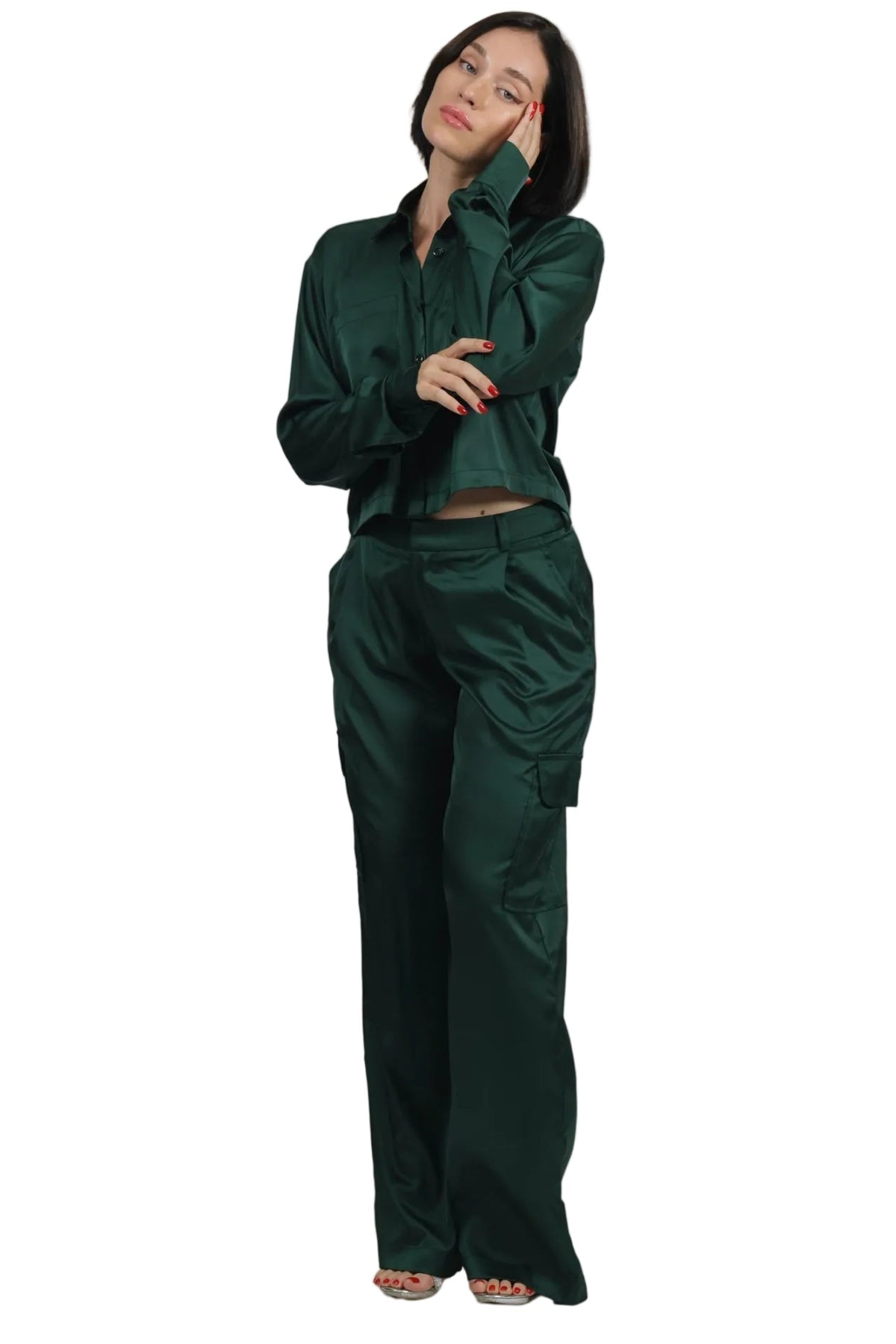 Woman wearing a green outfit against a beige background