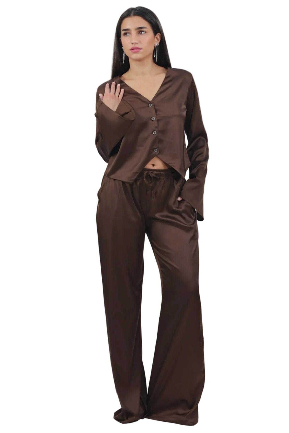 A woman modeling a matching brown satin pajama set consisting of a long-sleeve button-front top and wide-leg pants, photographed against a plain white background.