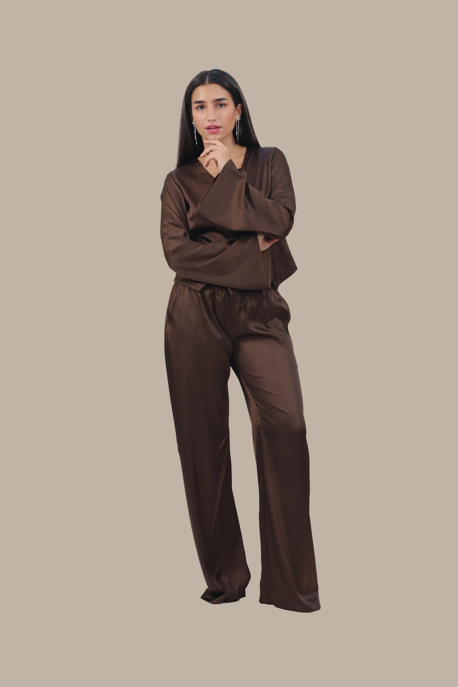 Woman wearing a brown outfit on a beige background