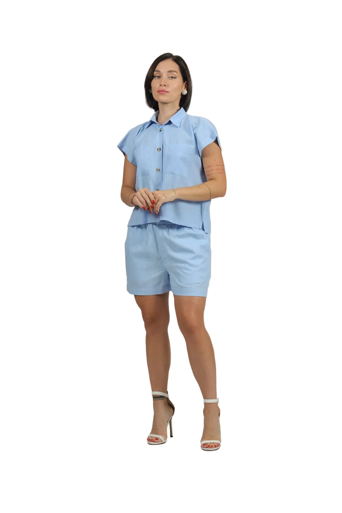 Woman wearing a light blue outfit with a matching top and shorts on a beige background