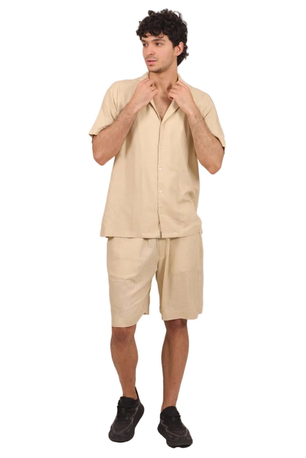A man modeling a light beige linen short-sleeve button-up shirt and matching linen shorts against a solid white background.