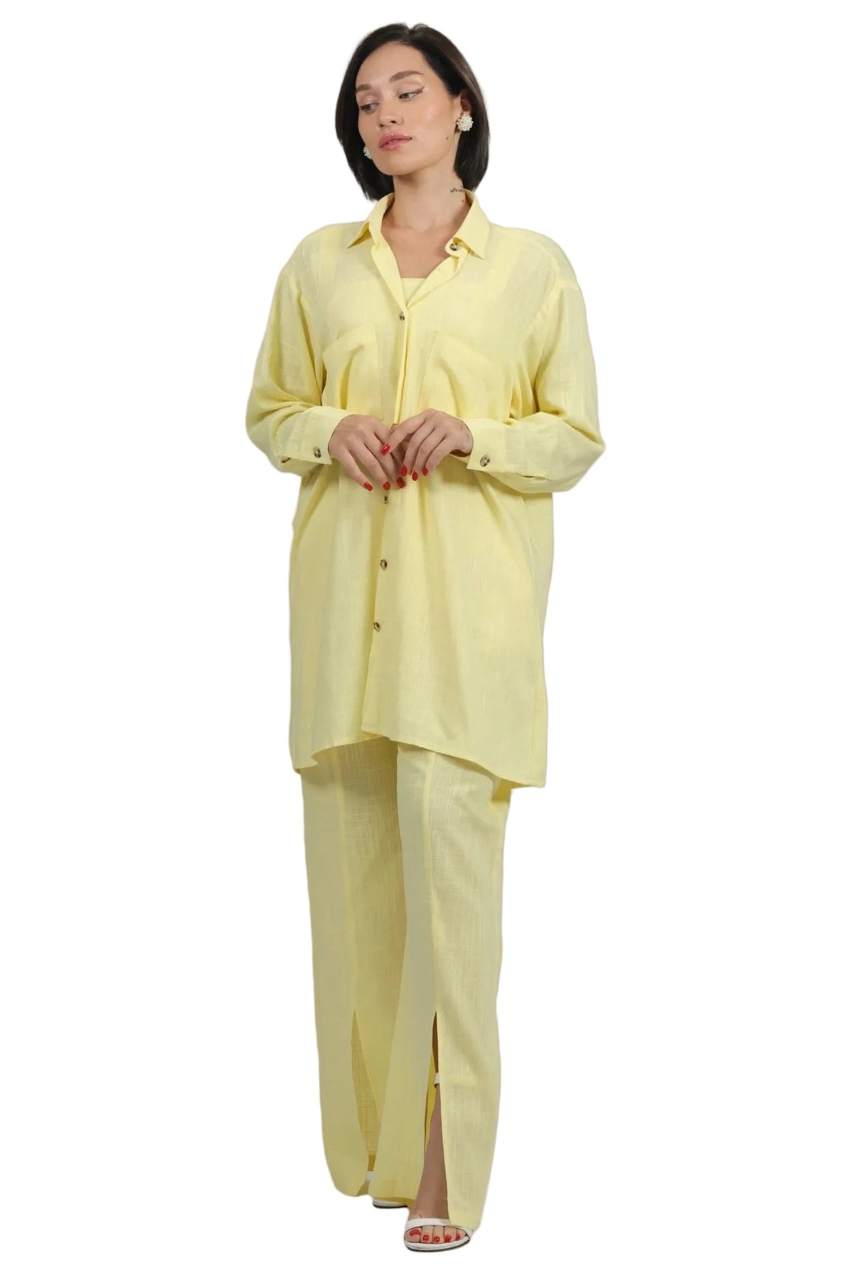 A woman modeling a light yellow two-piece lounge set consisting of a long-sleeve button-up shirt and matching wide-leg pants, set against a plain white background.