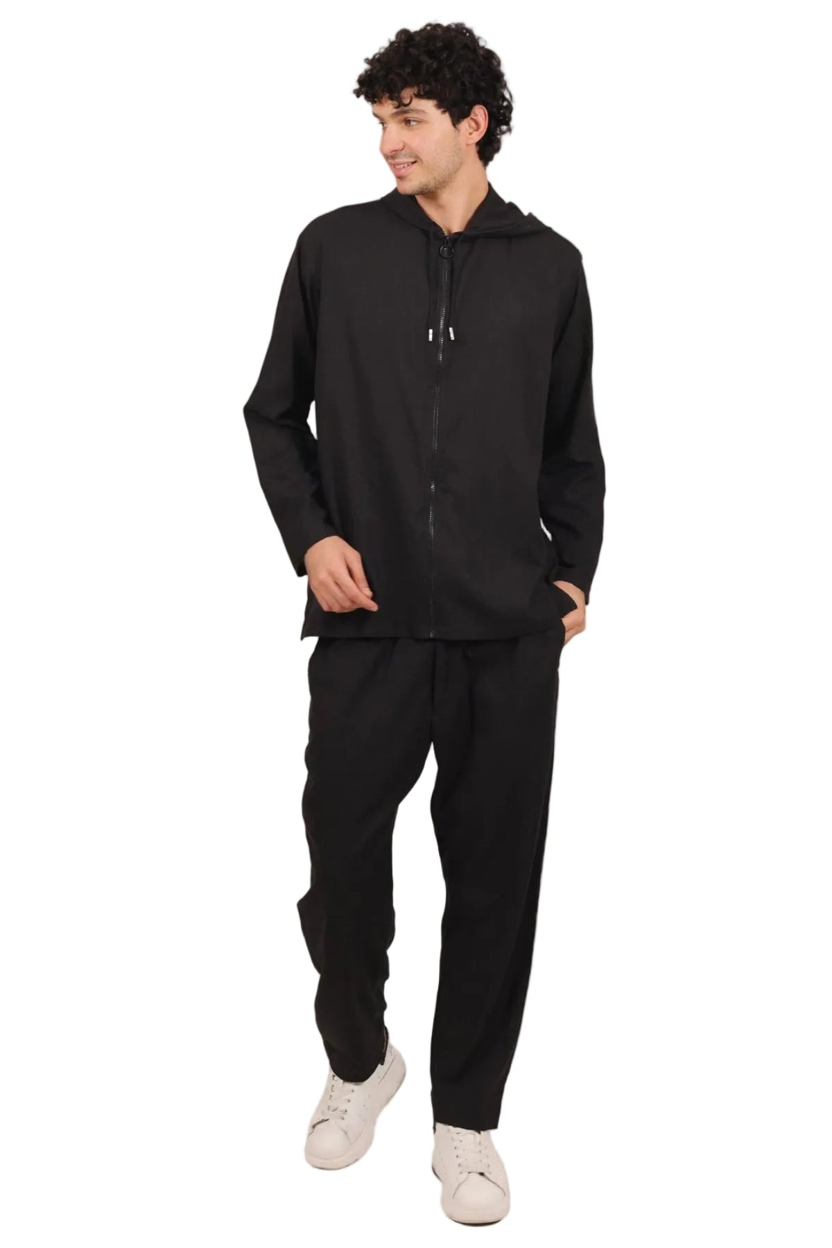 Man wearing a black hoodie and pants on a beige background