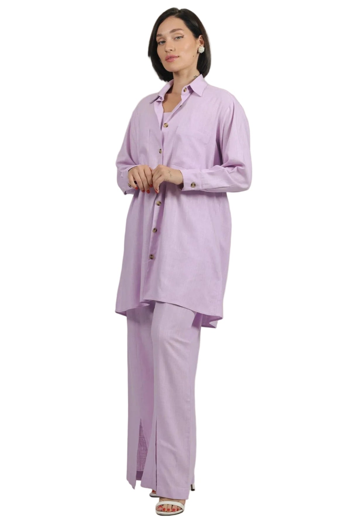 A woman modeling a light purple/lavender two-piece lounge set consisting of a long-sleeve button-up shirt and matching wide-leg pants, shot against a solid white background.