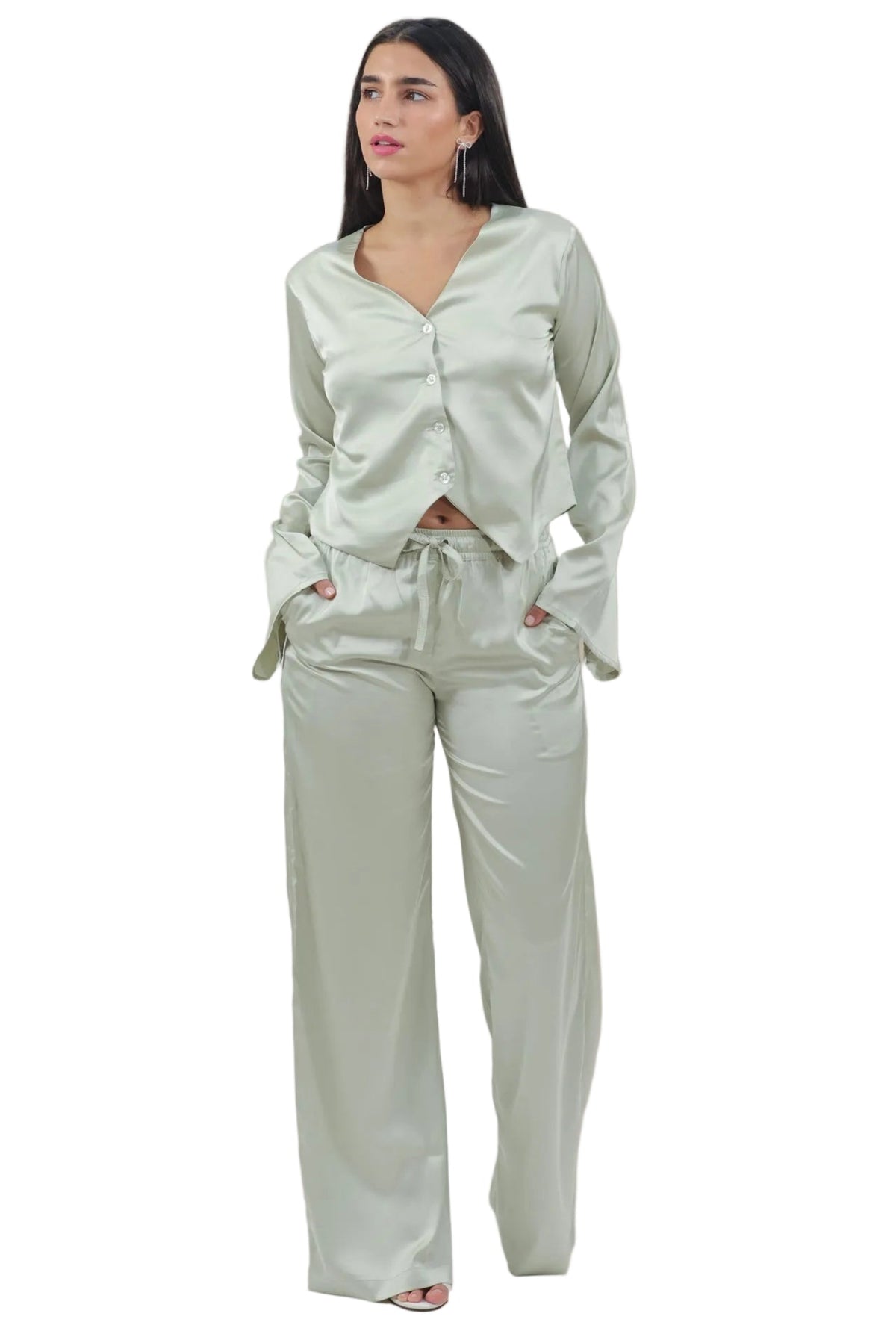 Woman wearing a light green outfit on a beige background