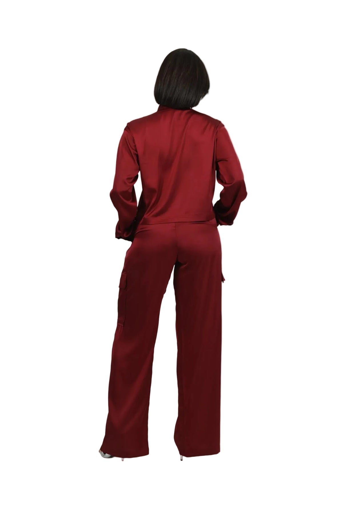 Person wearing a red satin outfit on a beige background