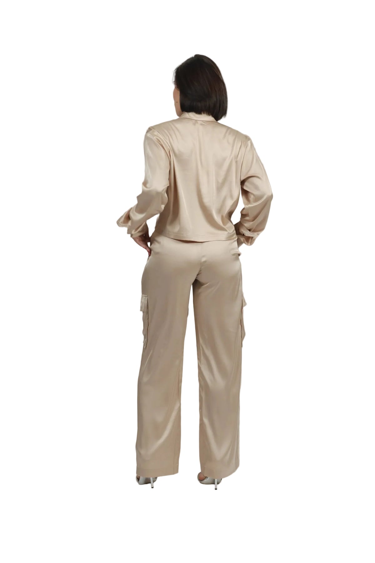 Person wearing a beige outfit with a plain background