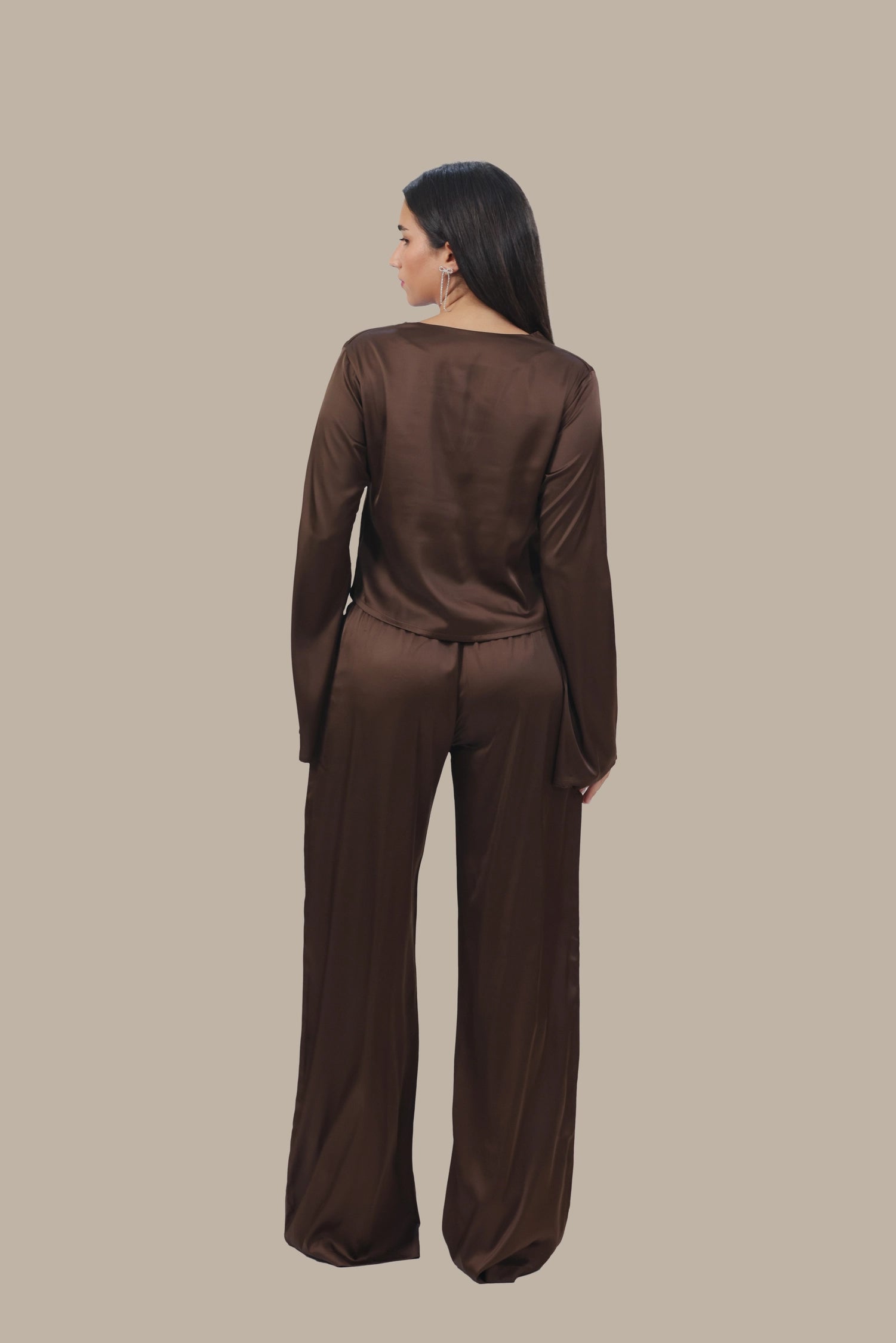 Woman wearing a brown outfit on a beige background