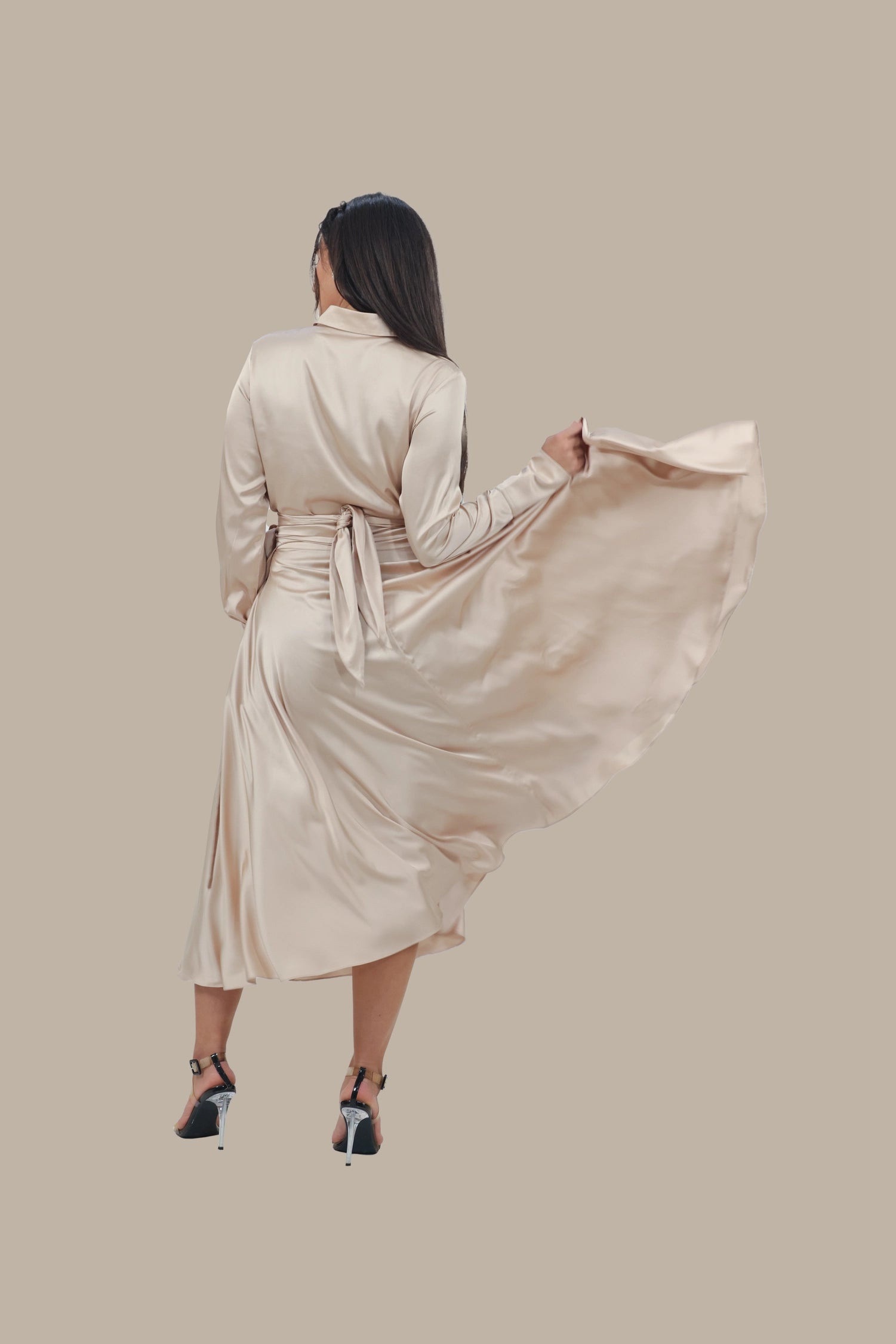 Woman wearing a beige robe against a beige background