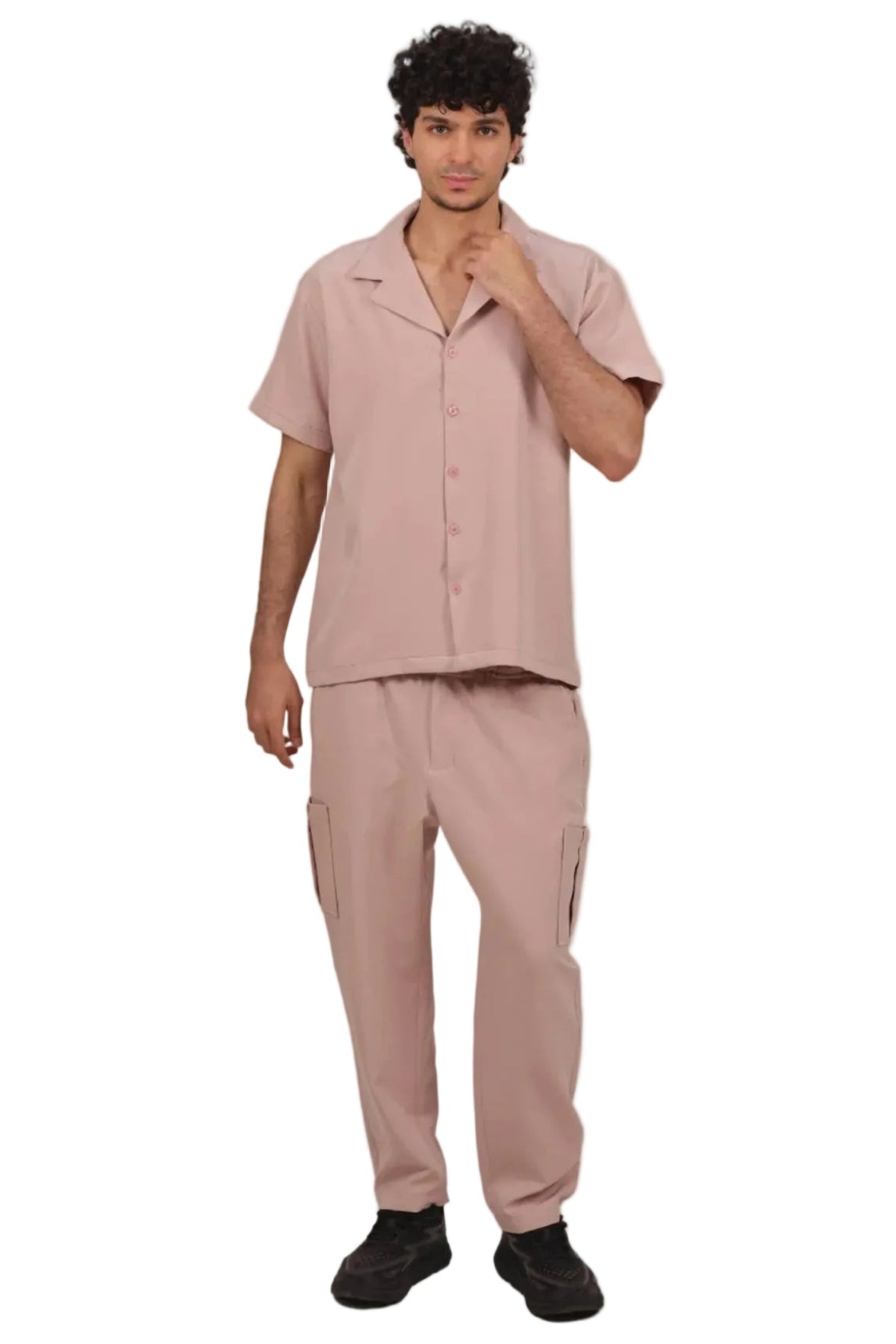 Man wearing a matching pink shirt and pants set on a beige background