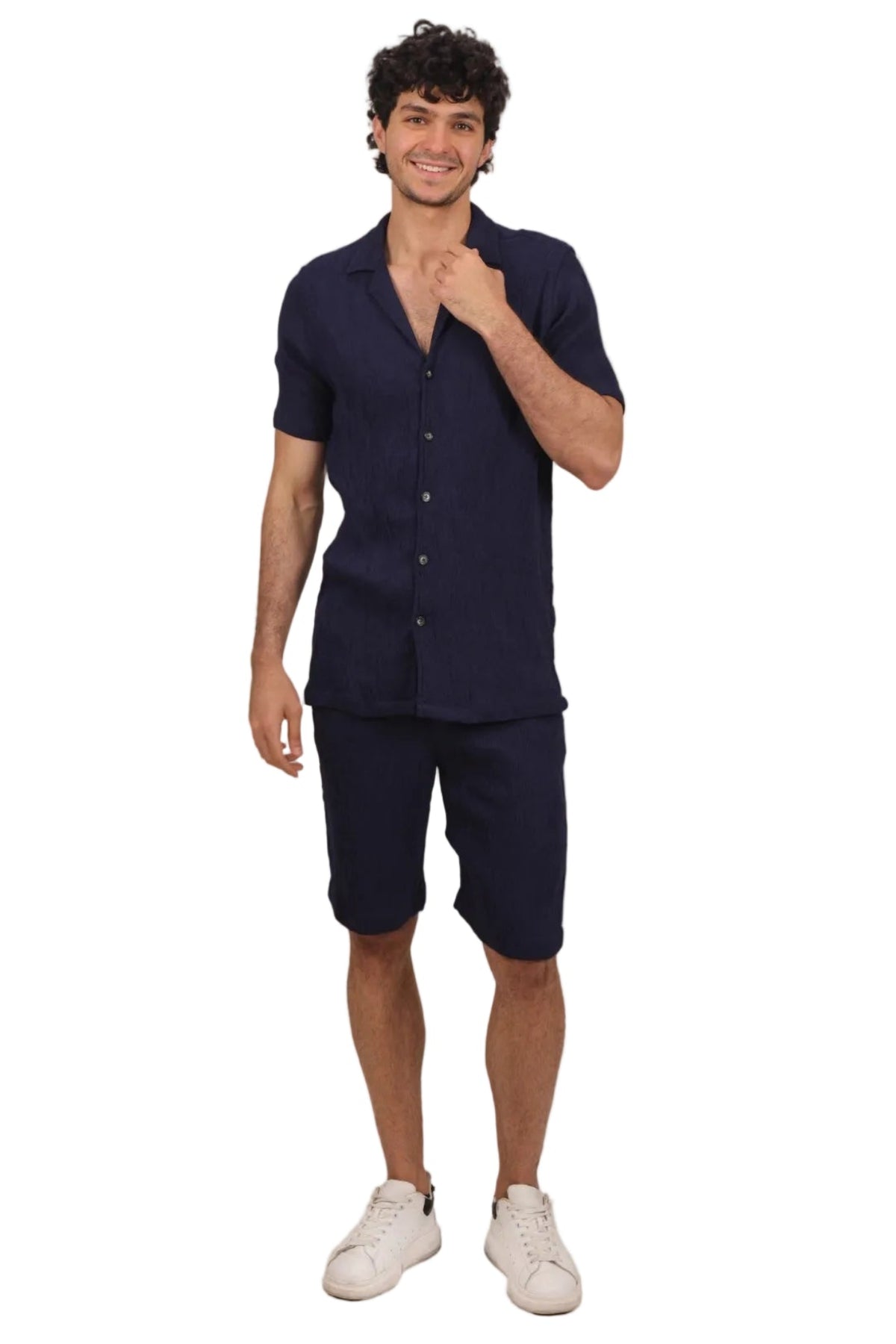 Man wearing a navy shirt and shorts set on a beige background
