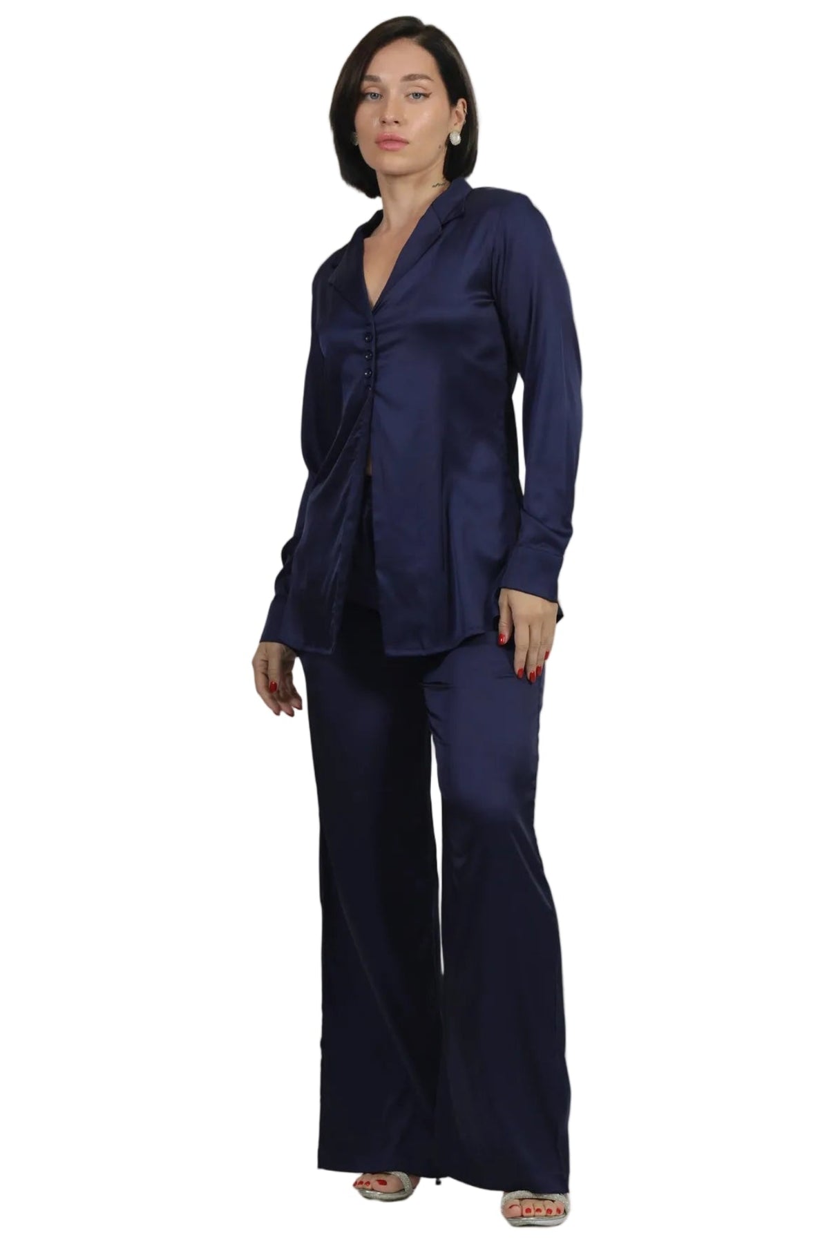 A woman modeling a matching navy blue two-piece set consisting of a long-sleeve wrap-style blouse and wide-leg trousers, photographed against a solid white background.