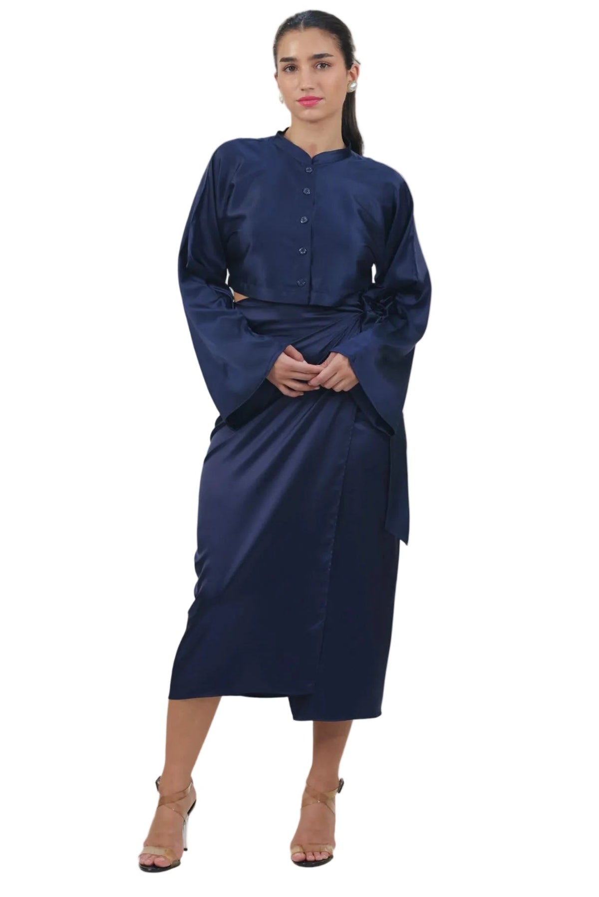 A woman modeling a dark navy blue long-sleeved dress with a buttoned collar and a matching fabric belt, standing against a solid white background.