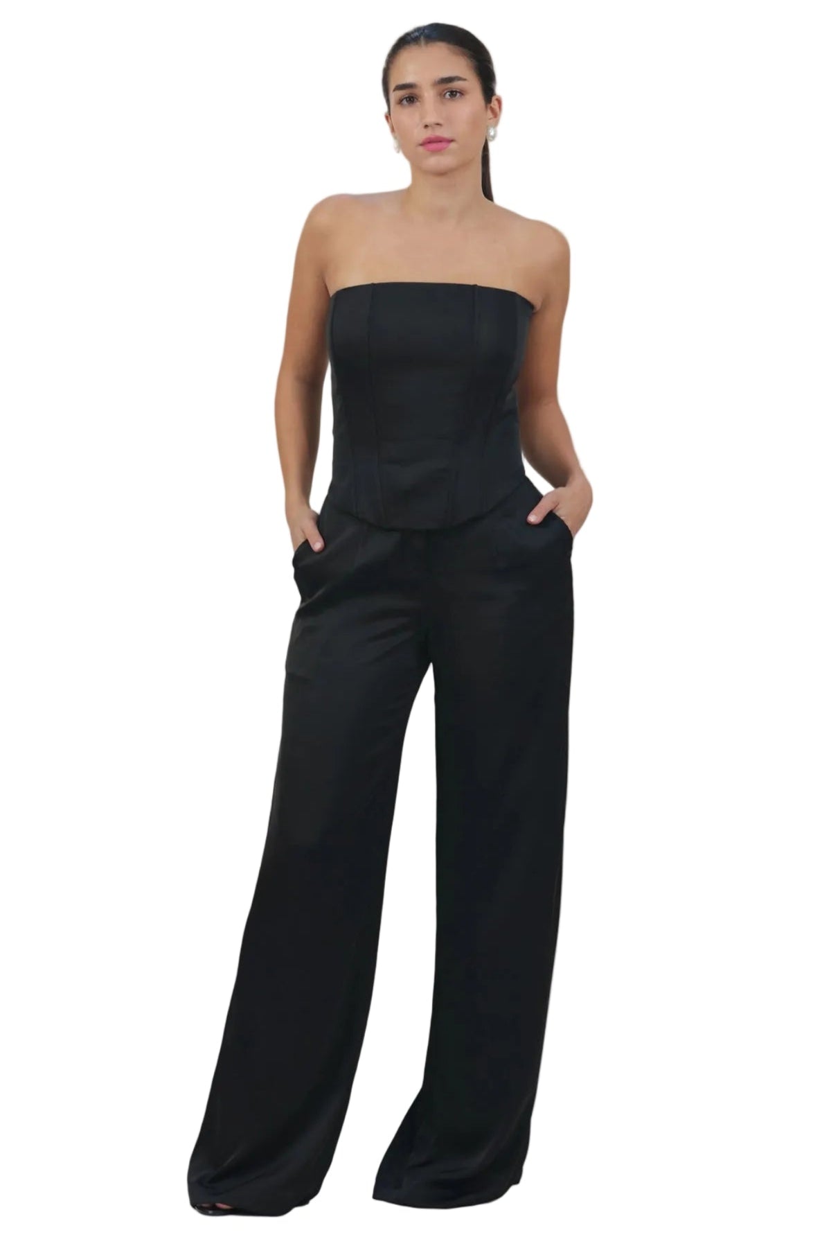 Woman wearing a black strapless jumpsuit on a beige background