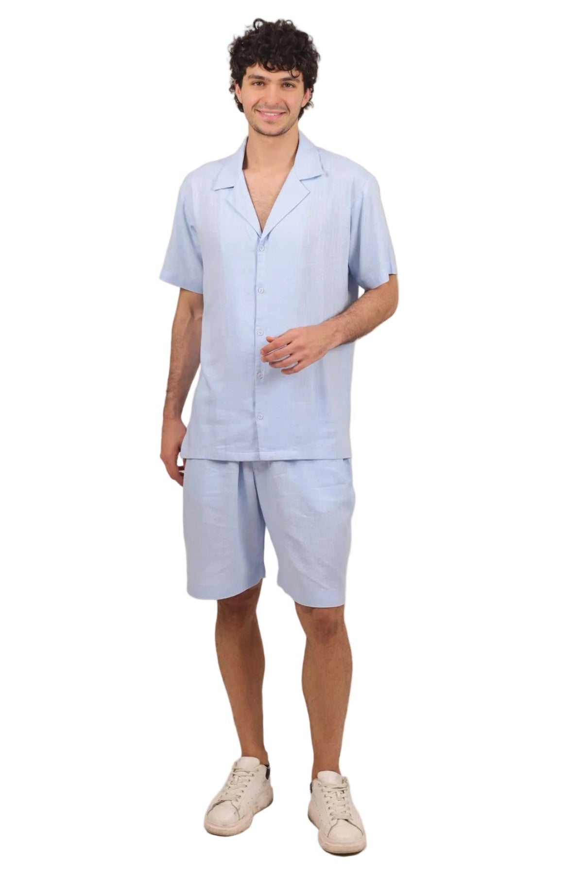 A man modeling a light blue short-sleeve button-up pajama shirt and matching shorts against a solid white background.