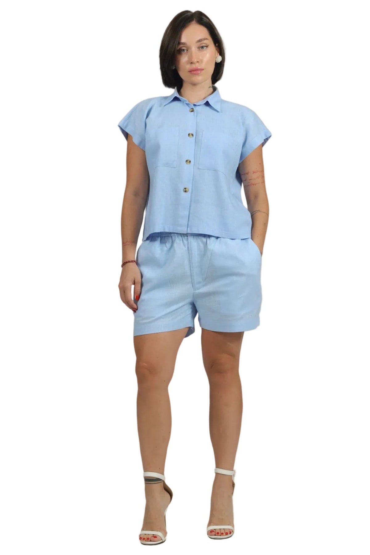 Woman wearing a light blue outfit on a beige background
