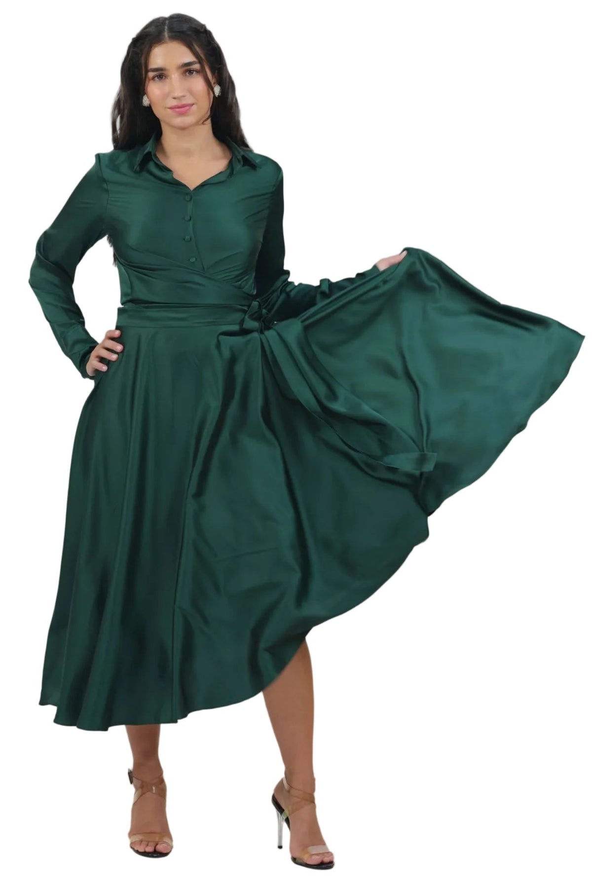 A woman modeling a dark green long-sleeve midi dress with a button-up collar and a flared skirt that swirls outward, shown against a plain white background.