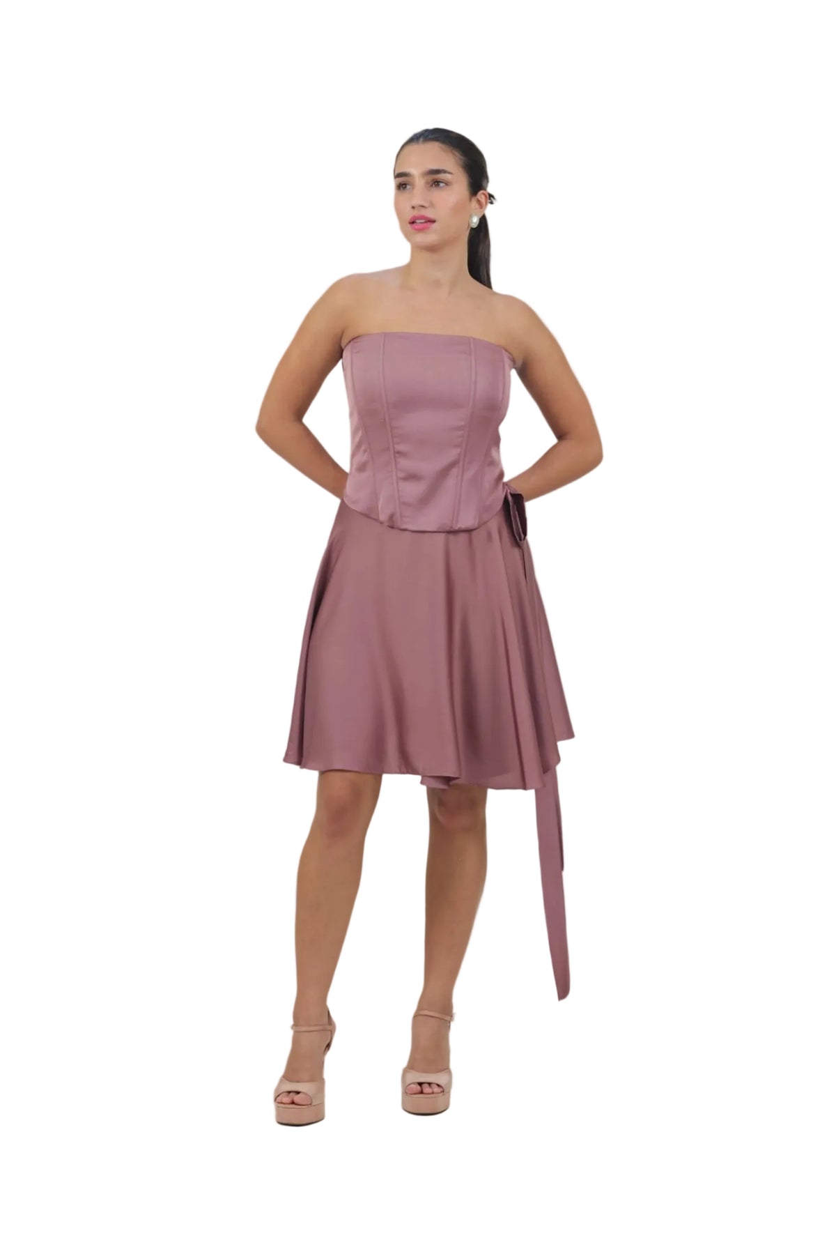 Woman wearing a strapless pink dress with a belt on a beige background