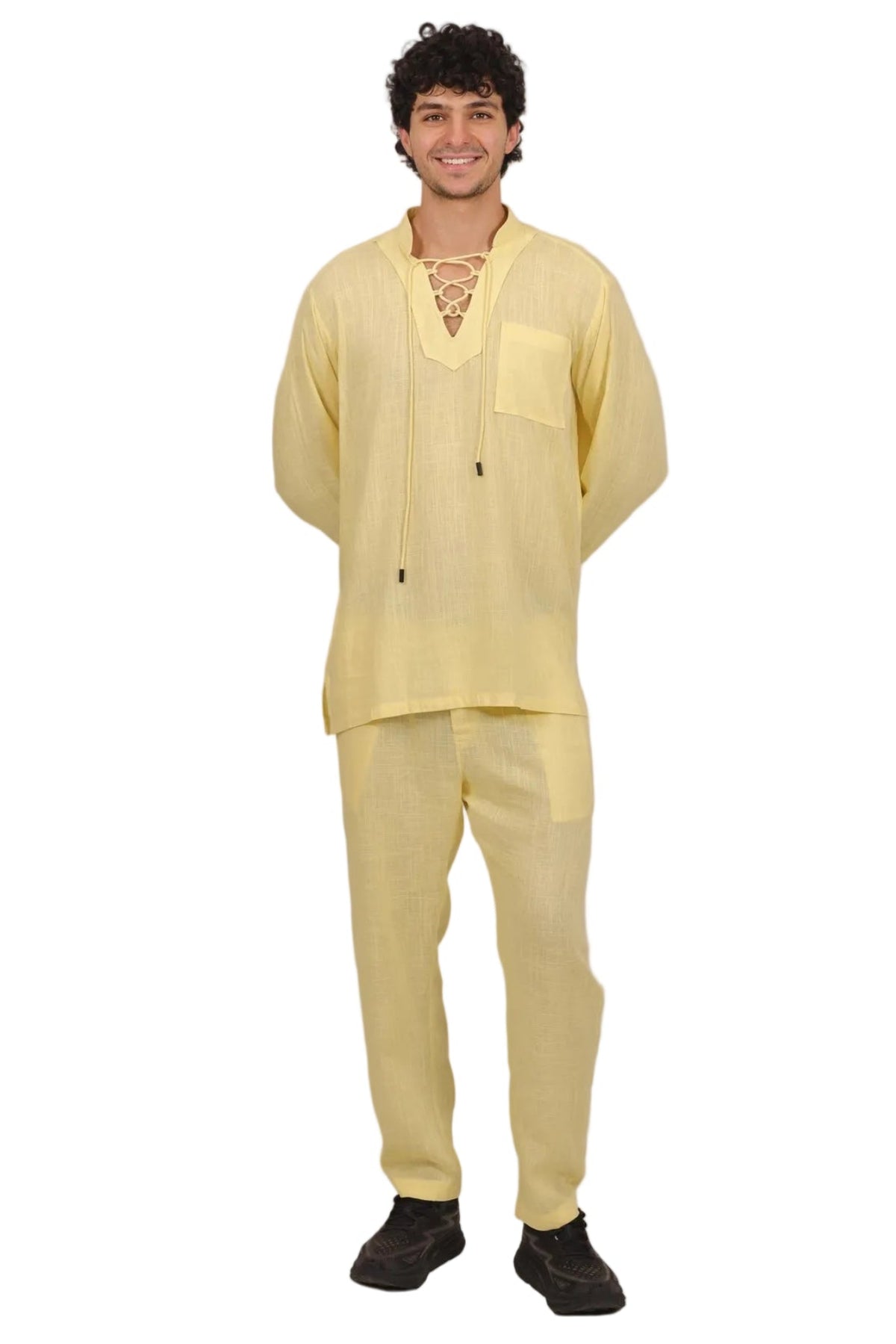 A man modeling a light yellow traditional two-piece outfit consisting of a long-sleeve kurta with a lace-up front and matching trousers, set against a plain white background.
