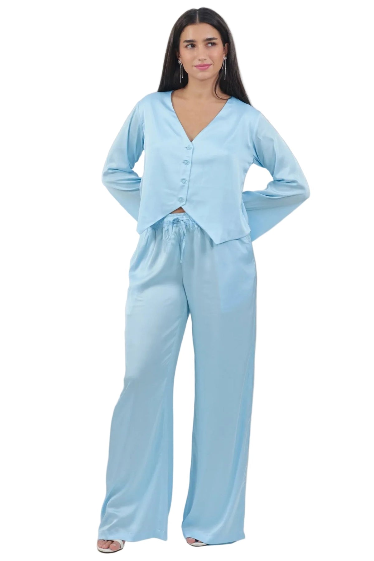 A woman modeling a light blue two-piece lounge set consisting of a cropped button-front long-sleeve top and matching wide-leg pants, photographed against a plain white background.