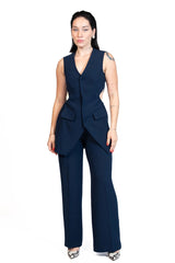 A woman modeling a navy blue sleeveless vest and matching wide-leg trousers set against a plain white background.