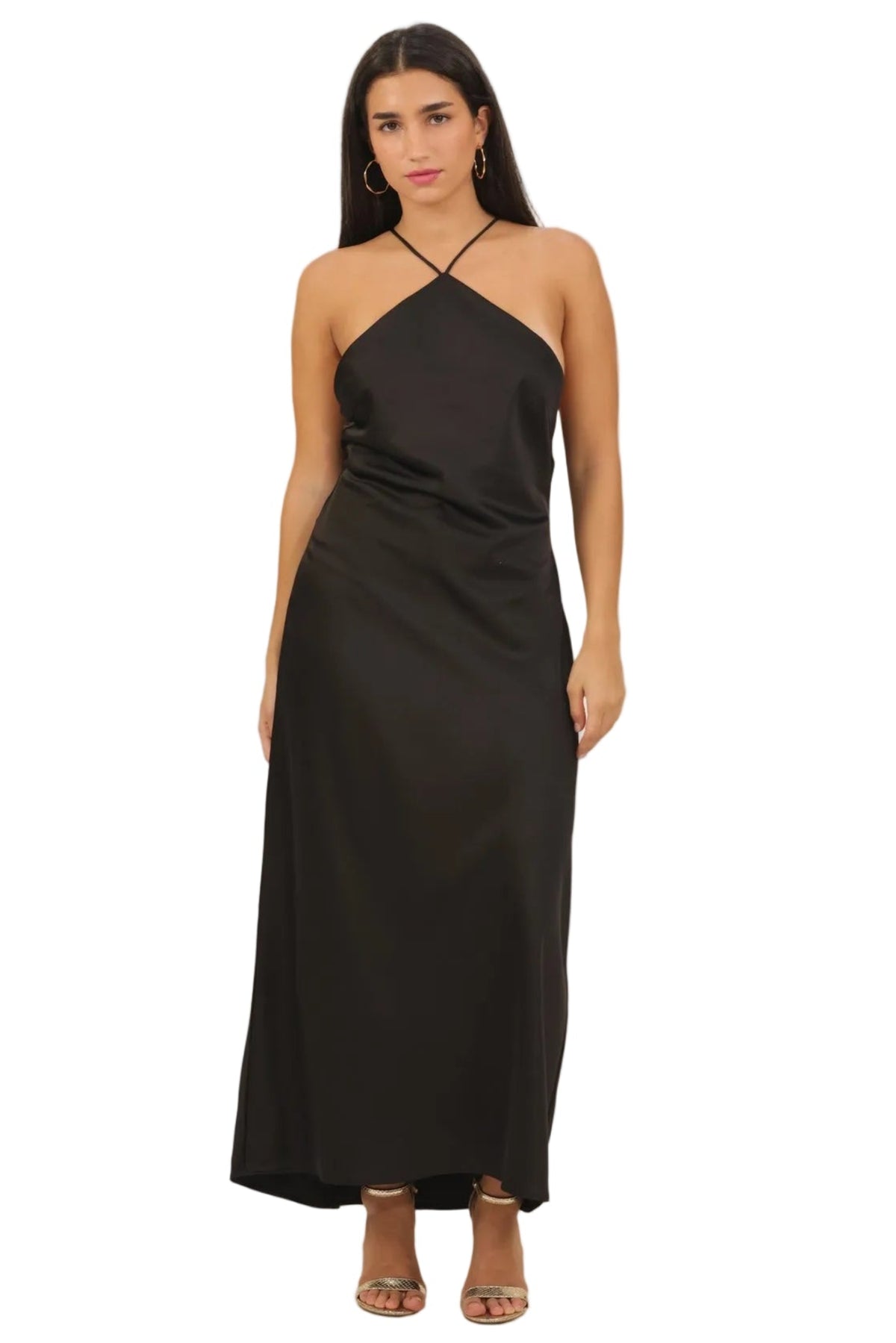 A woman modeling a black halter-neck maxi dress with thin crisscross straps, photographed against a plain white background.