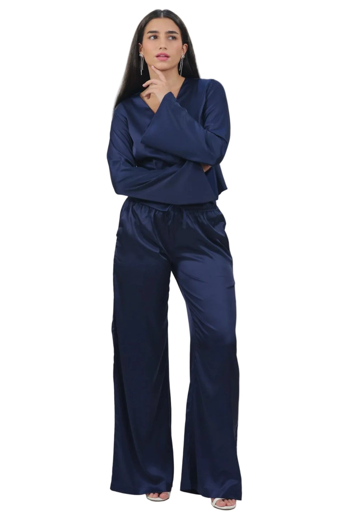 A woman modeling a matching navy blue two-piece lounge set consisting of a long-sleeve top and wide-leg pants, set against a plain white background.