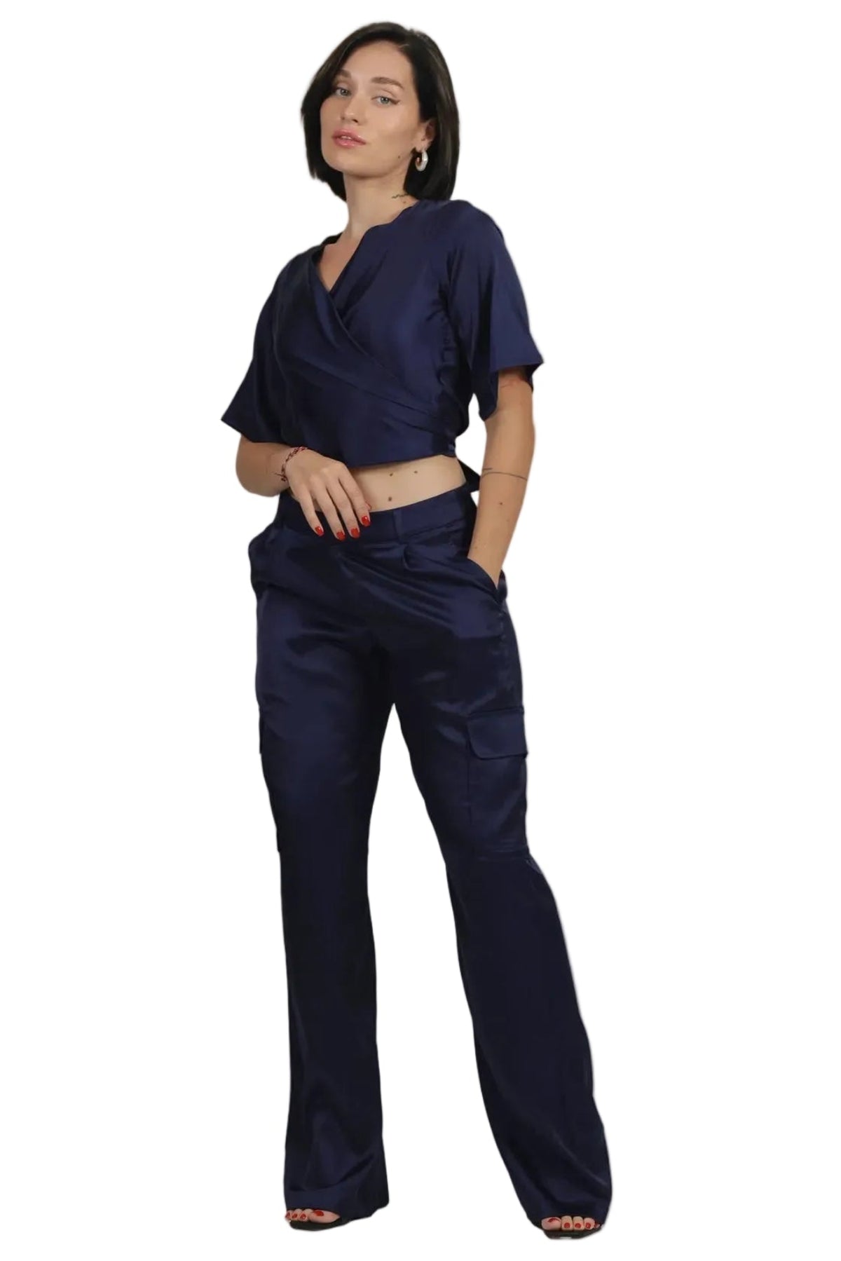 A woman modeling a matching navy blue two-piece set consisting of a short-sleeve wrap-style crop top and high-waisted wide-leg trousers, shown against a plain white background.