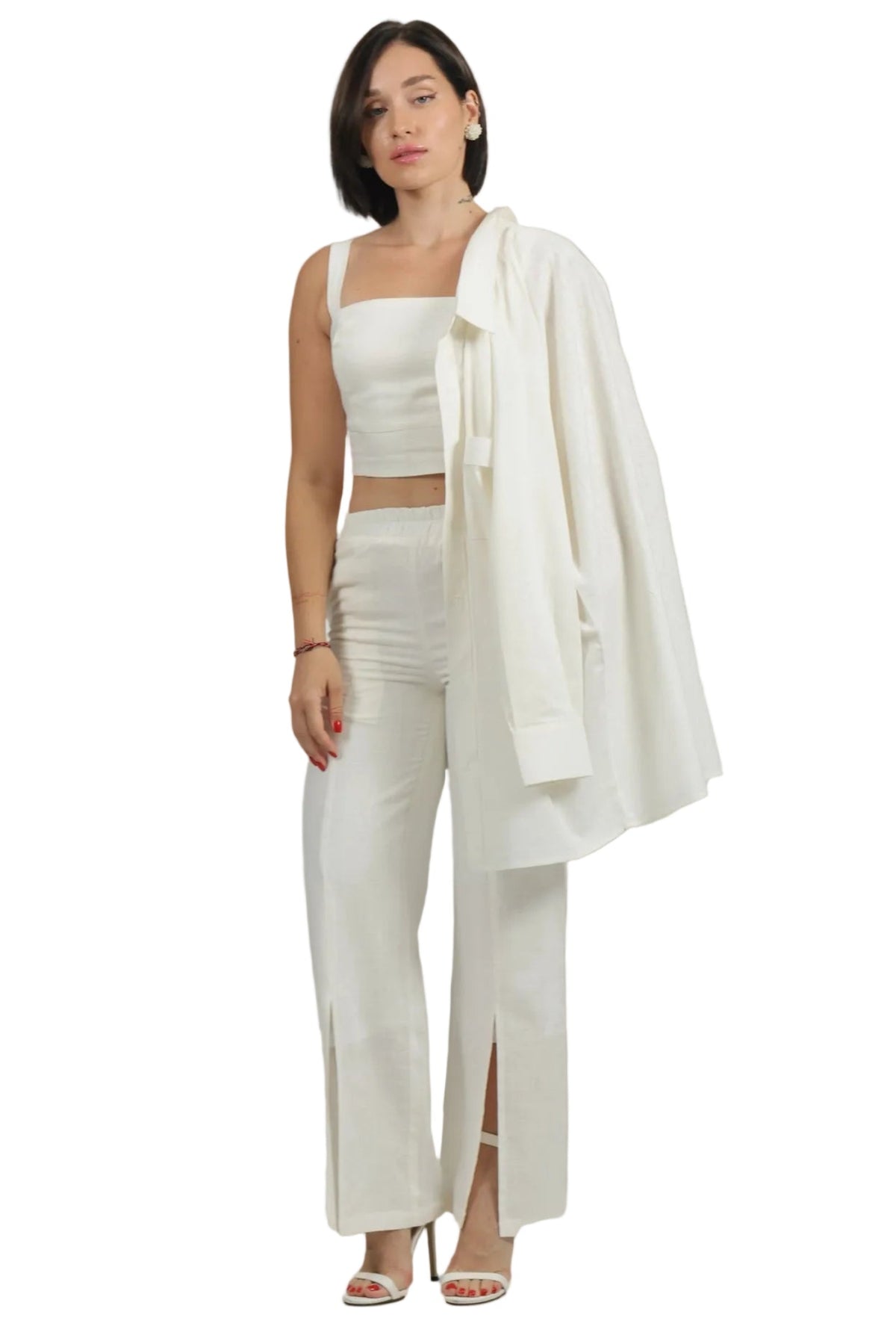 Woman wearing a white outfit with a shawl on a beige background