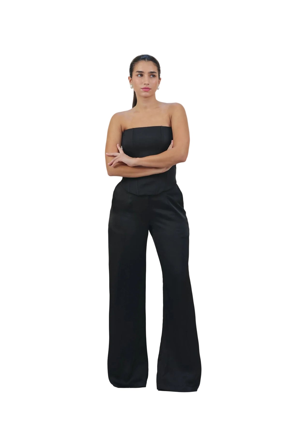 Woman wearing a black strapless top and wide-leg pants on a beige background