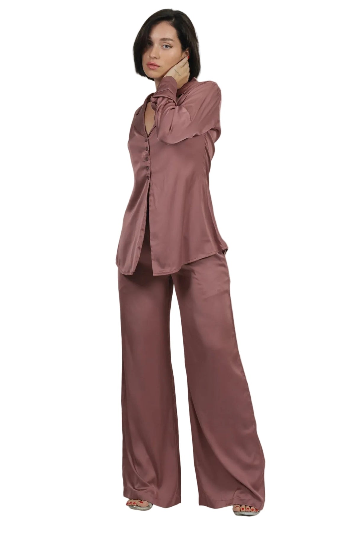 A woman modeling a matching two-piece lounge set in a dusty rose color, featuring a long-sleeve button-up shirt and wide-leg pants, set against a plain white background.