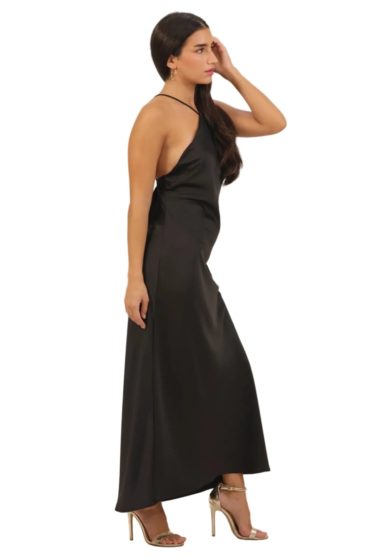A woman modeling a black satin halter maxi dress, shown from a side profile against a solid white background.