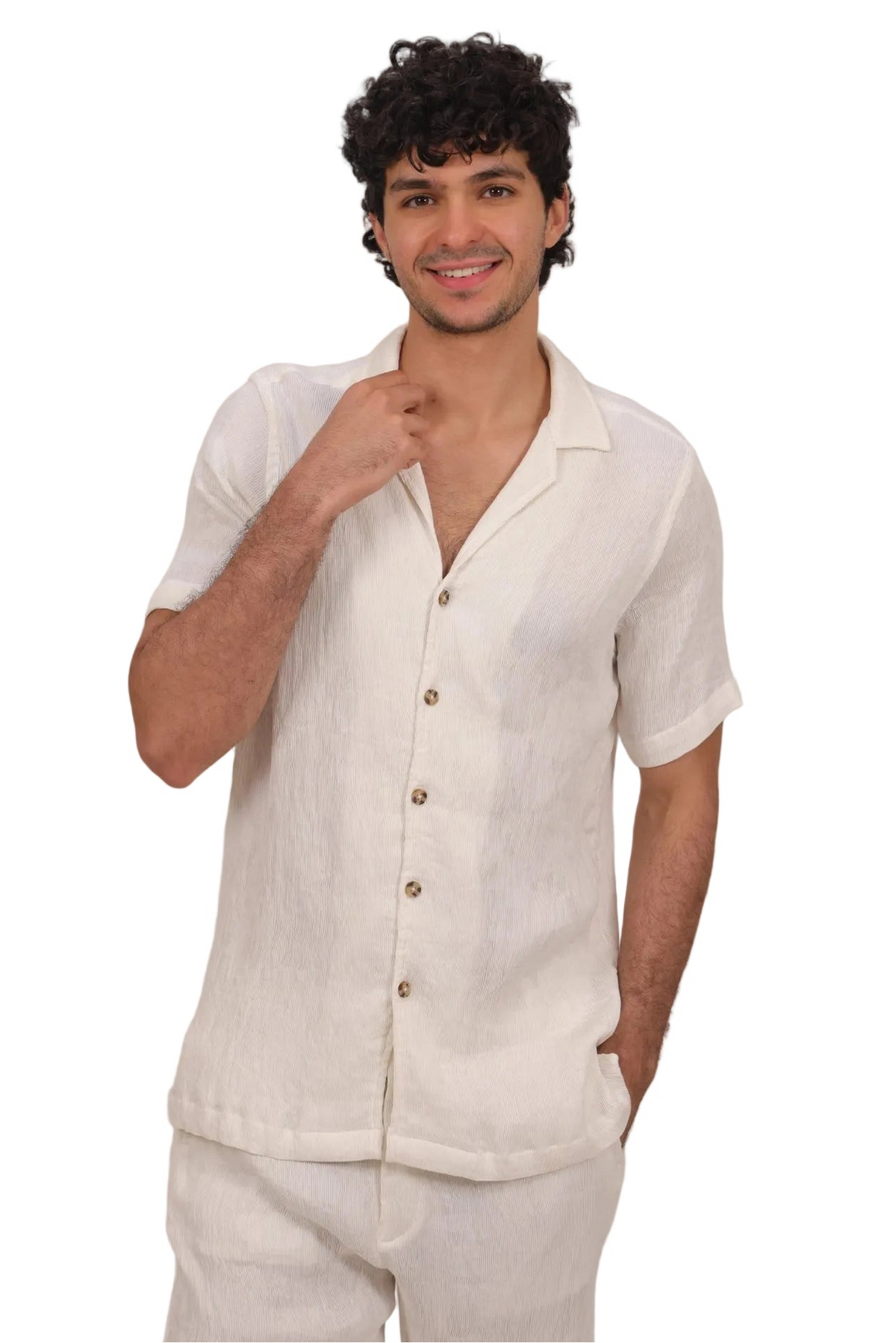 Man wearing a white linen shirt and pants against a beige background