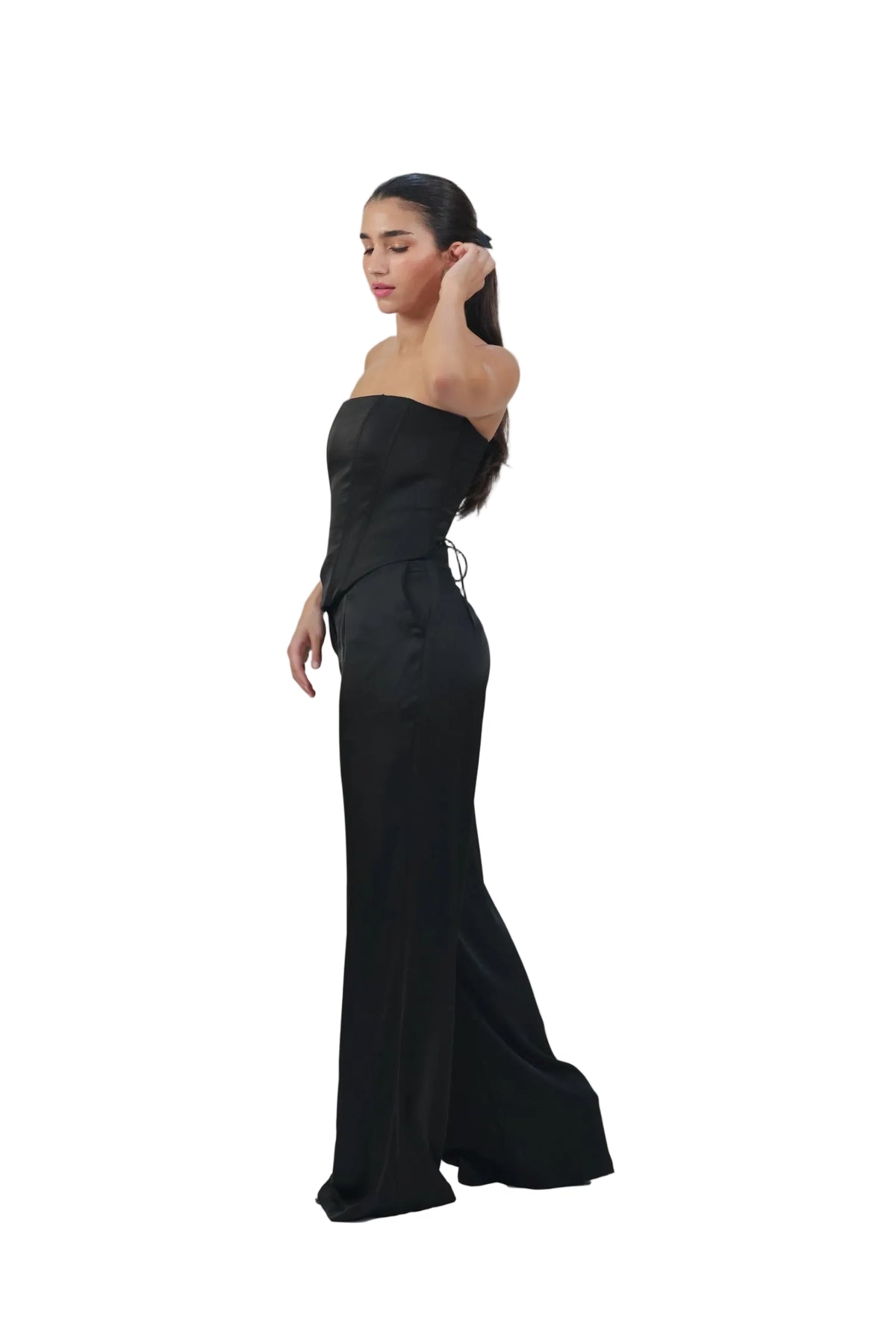 Woman wearing a black strapless gown against a beige background