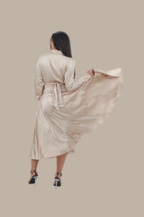 Woman wearing a beige robe against a beige background