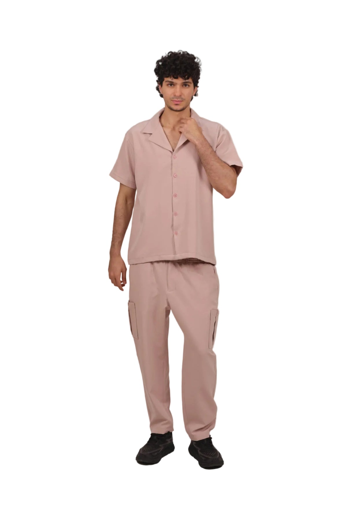 Man wearing a matching pink shirt and pants set on a beige background