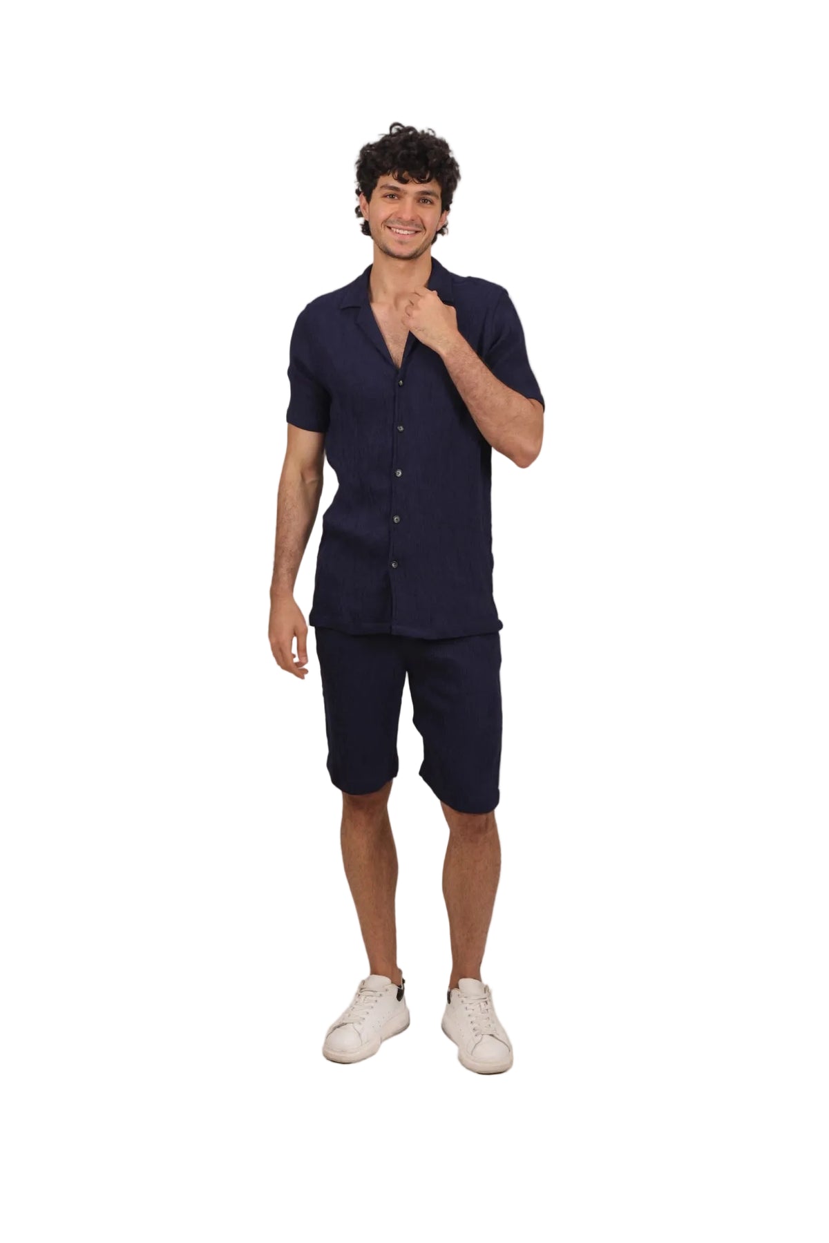Man wearing a navy shirt and shorts set on a beige background